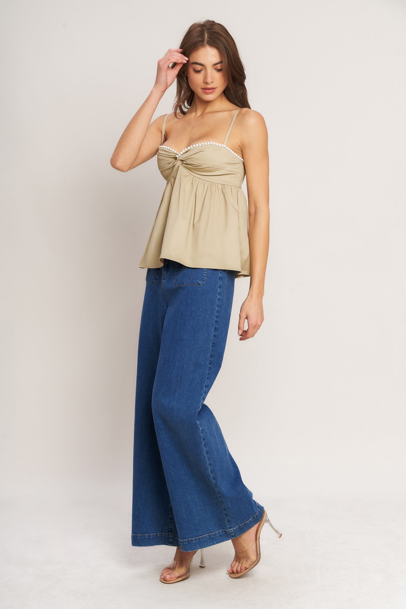 A taupe solid woven top featuring twisted bodice with bead trim, straps and back zipper closure