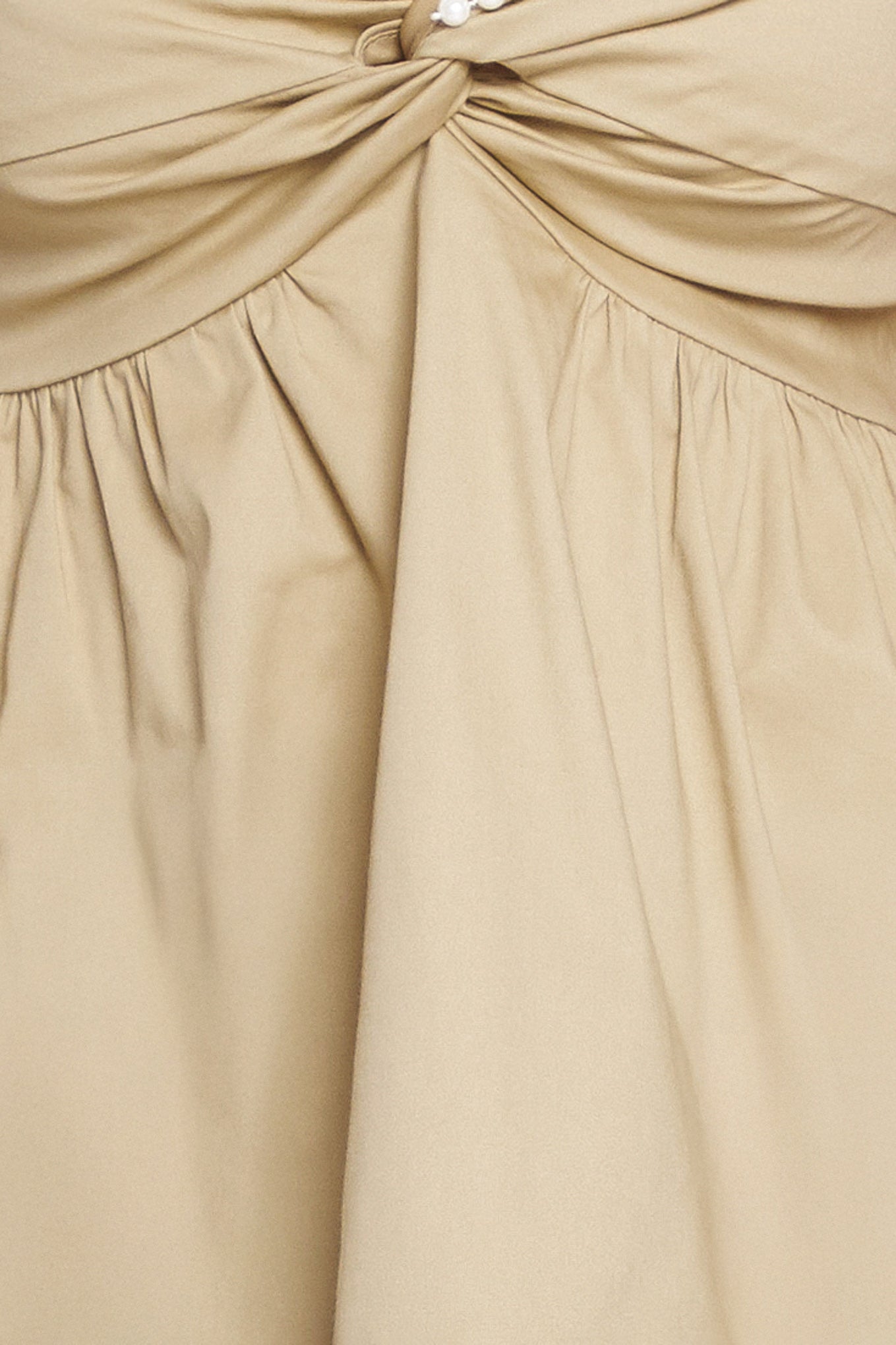 A taupe solid woven top featuring twisted bodice with bead trim, straps and back zipper closure