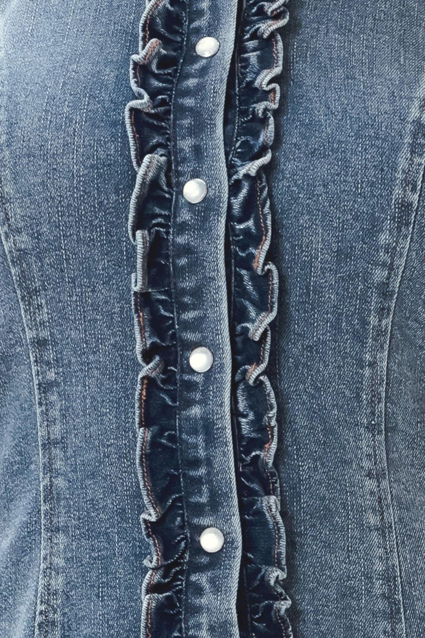 Close-up of blue denim fabric with ruffled trim and white buttons.