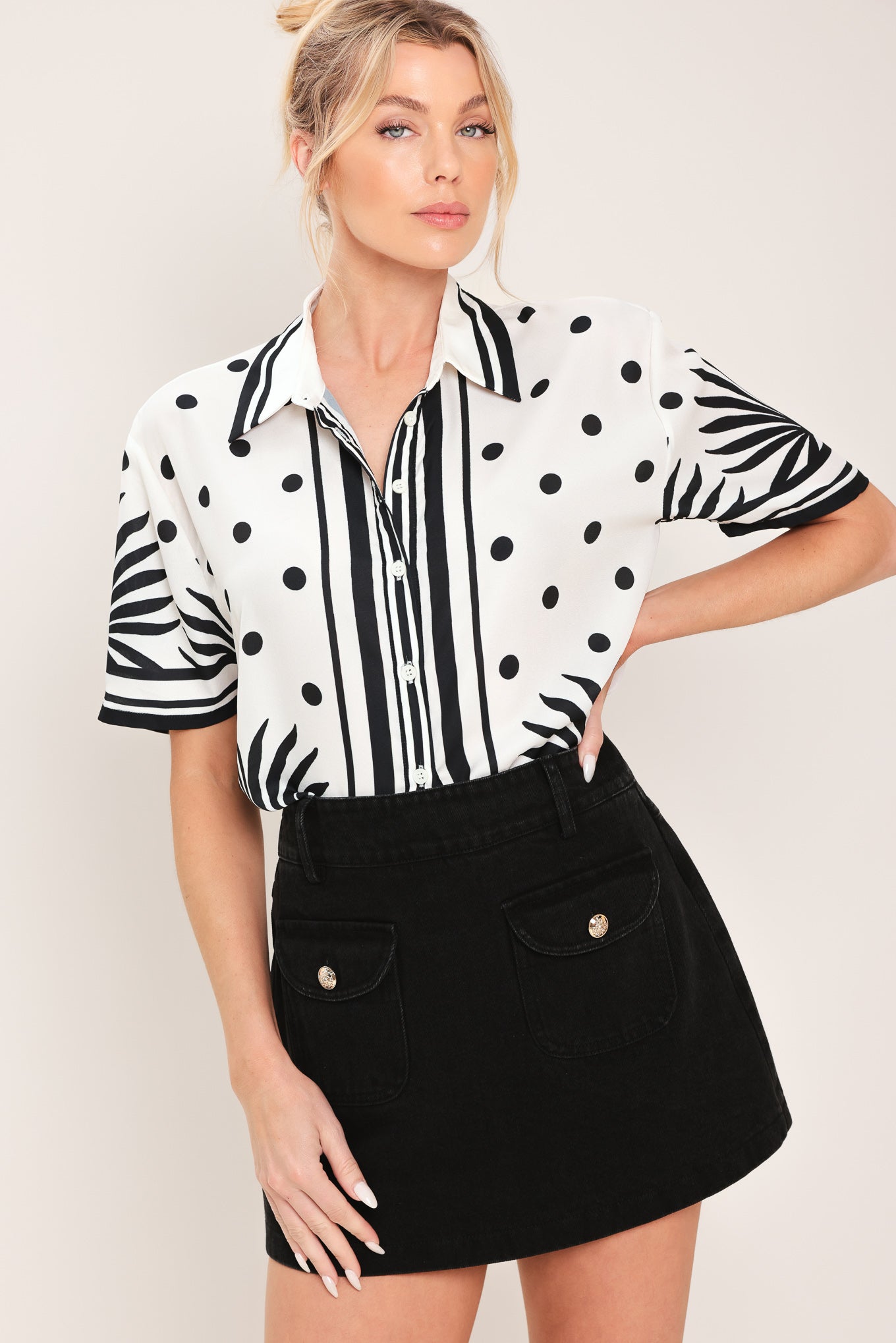 Woman wearing a white button up top with black polka dots and printed palms | Flying Tomato