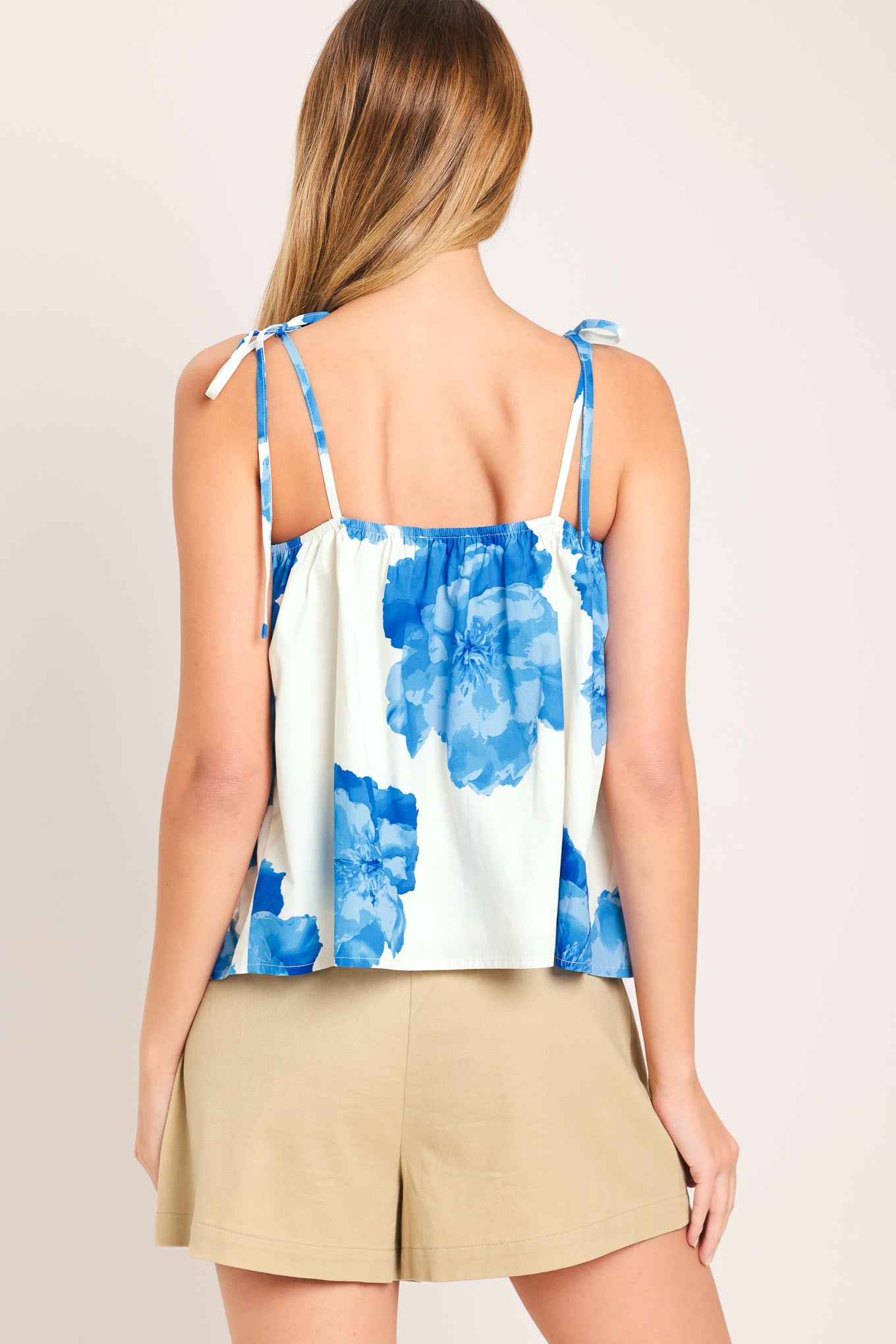 Woman wearing a blue floral top with shoulder ties | Flying Tomato