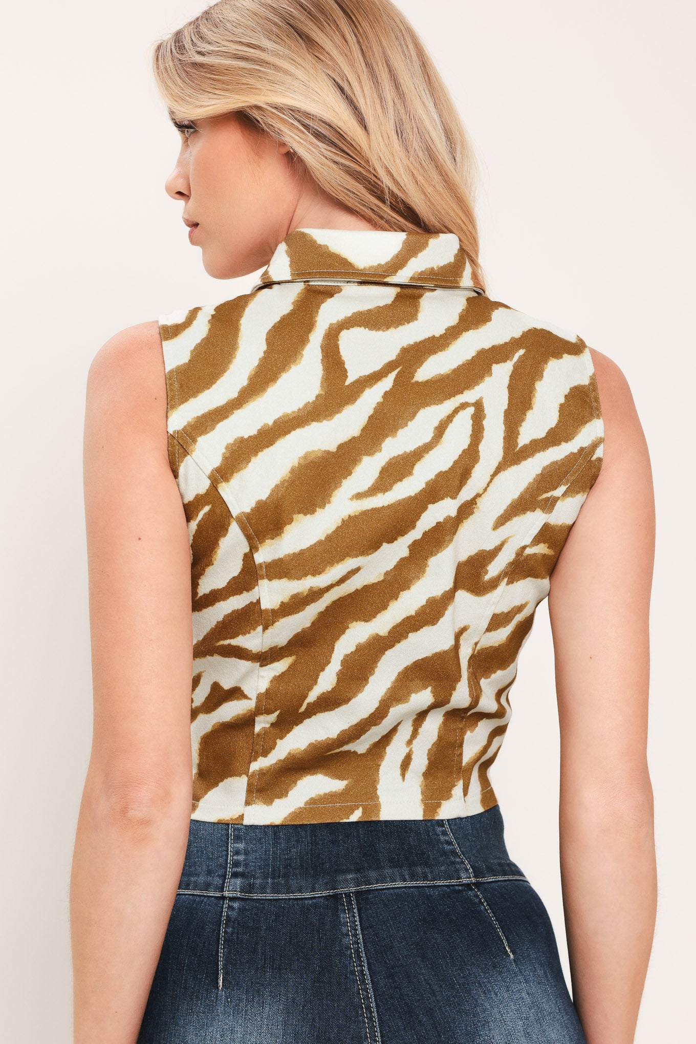 Woman wearing a sleeveless zebra print crop top with collar and front button down | Flying Tomato