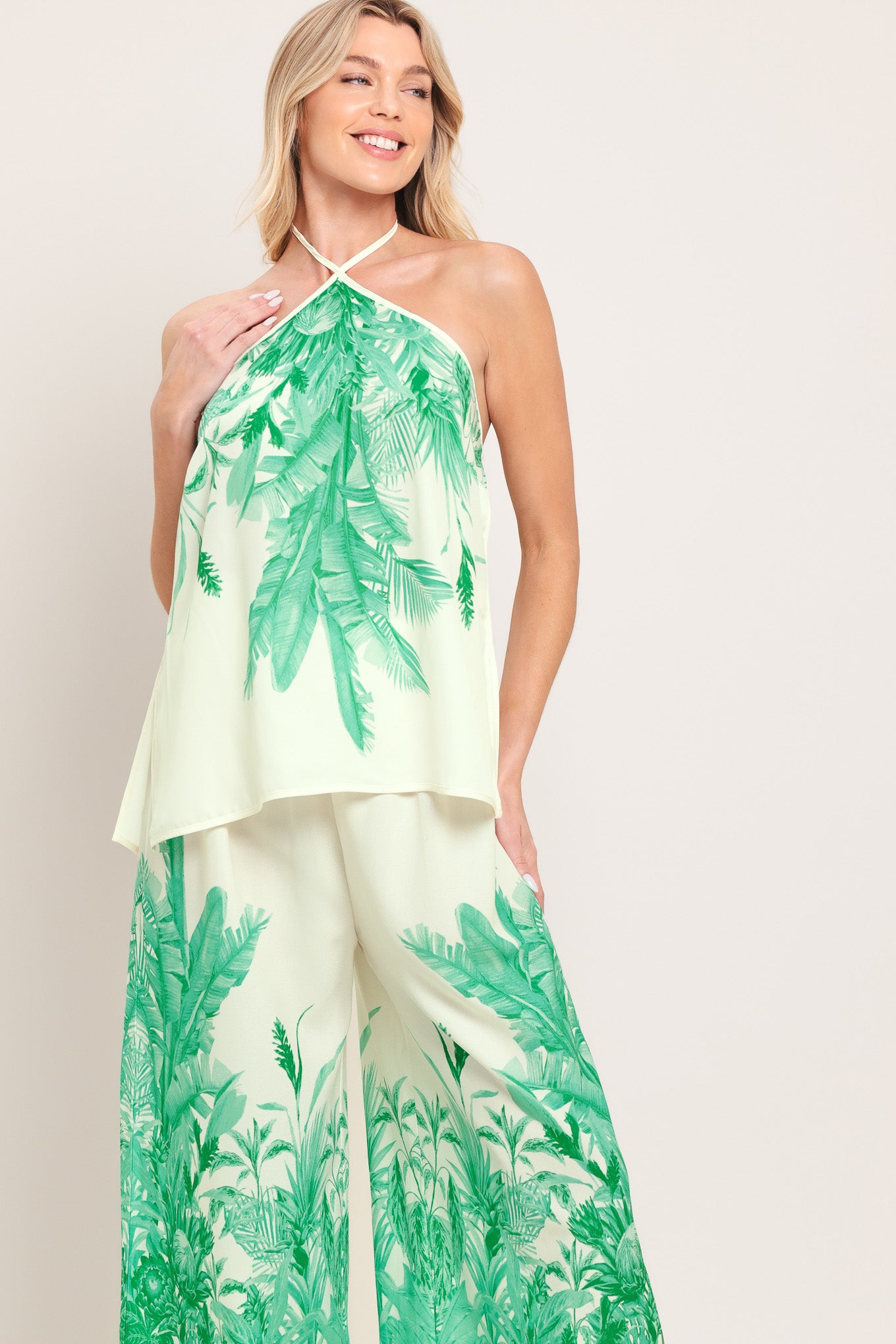 Woman wearing a halter top and pants set with green leaf pattern | Flying Tomato