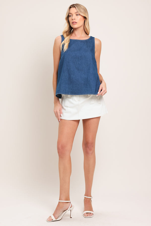Woman wearing a blue sleeveless denim top featuring round neckline and an open back with a bow | Flying Tomato