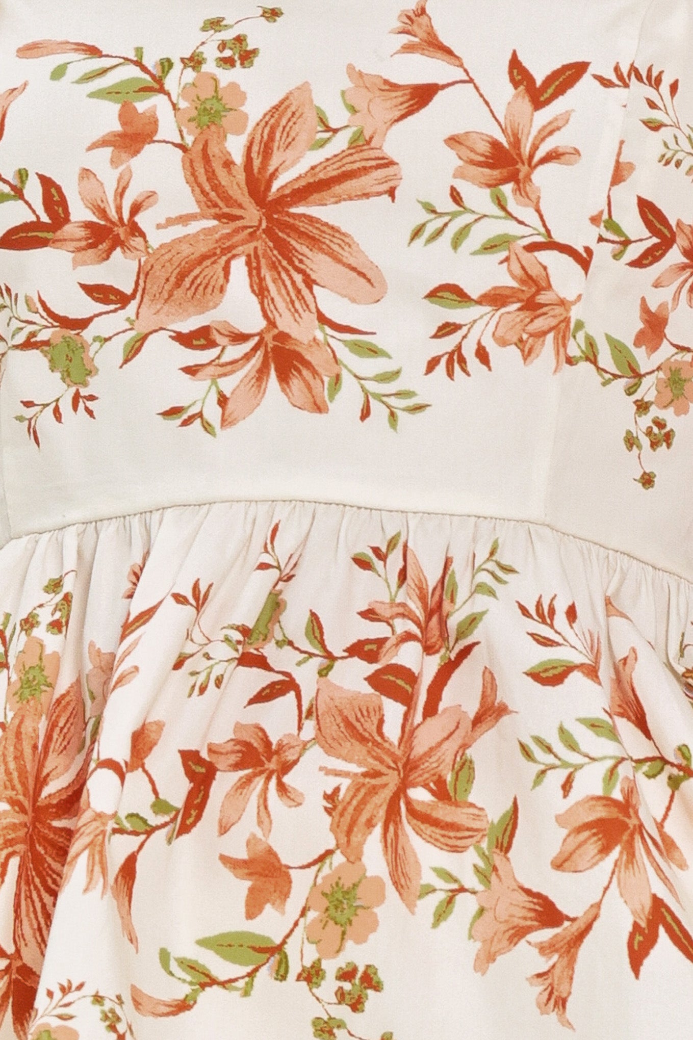 Woman wearing a floral peplum ivory top featuring straight neckline, shoulder ties, and smocked back bodice | Flying Tomato