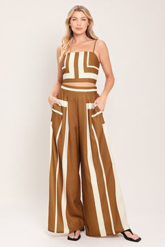 Woman wearing a brown and white geometrical top and pant set featuring crop top with straps and smocked back bodice, wide leg pant with elastic back | Flying Tomato