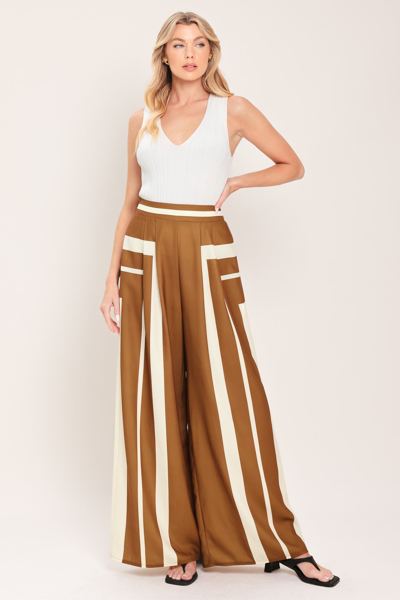 Woman wearing a brown and white geometrical pants featuring wide leg pant with elastic back | Flying Tomato