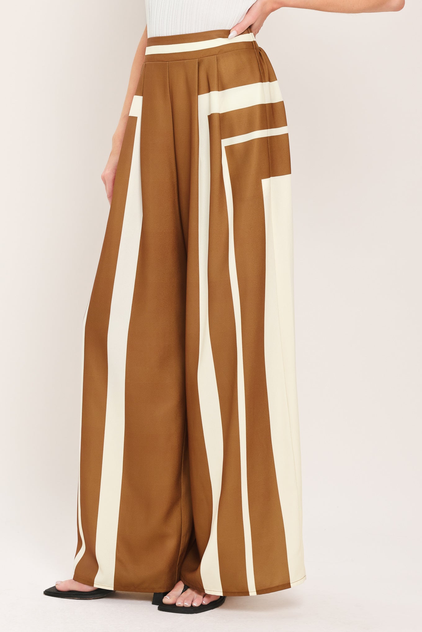 Woman wearing a brown and white geometrical pants featuring wide leg pant with elastic back | Flying Tomato