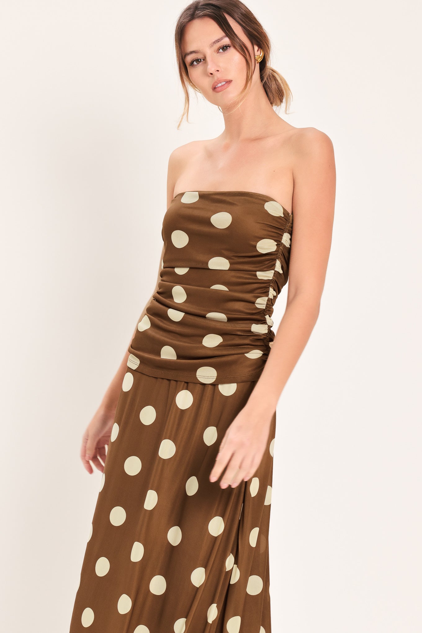 Woman wearing a brown strapless power mesh top with white polka dots and side shirring | Flying Tomato