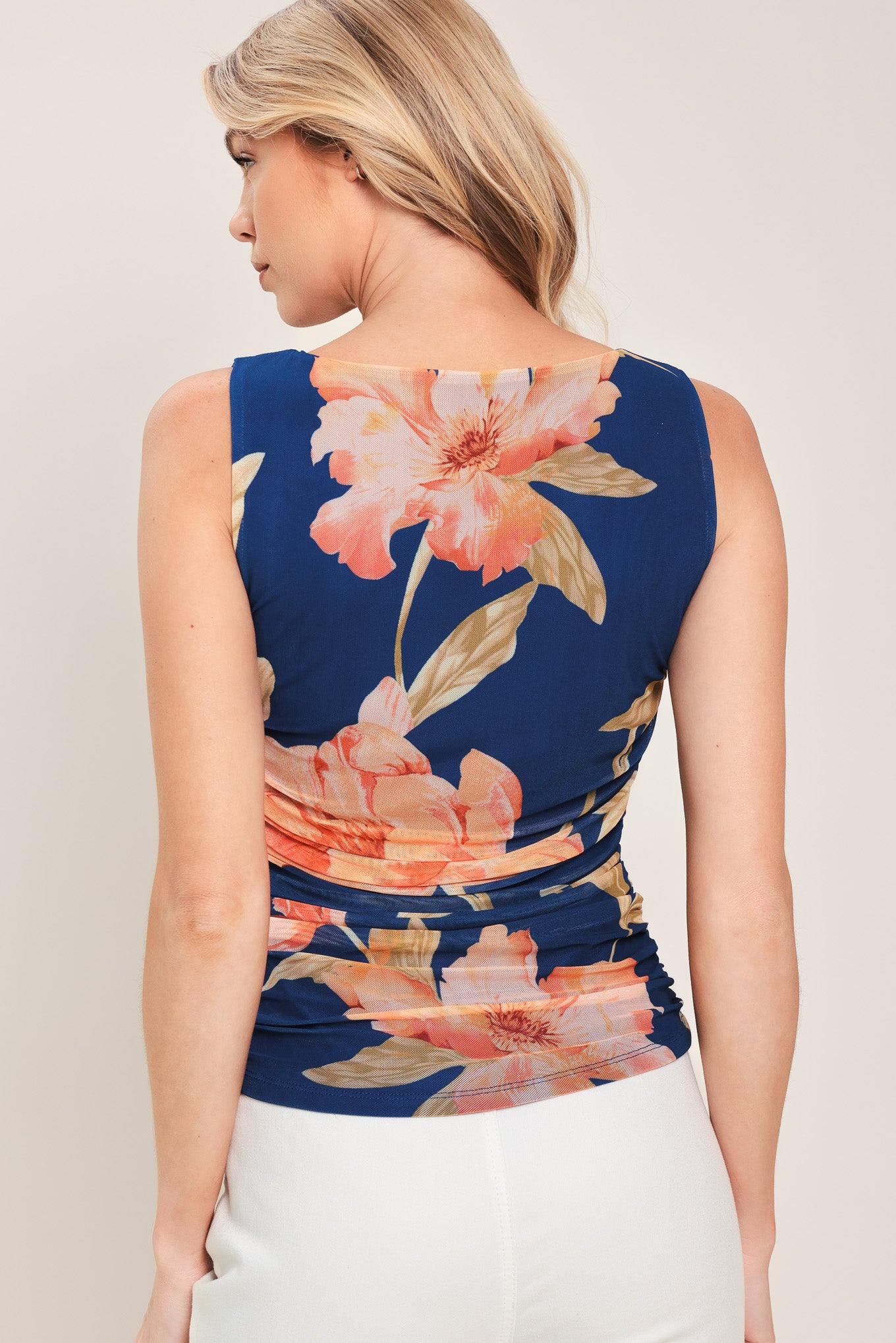 Woman wearing a navy blue with coral floral print power mesh tank top with side shirring | Flying Tomato