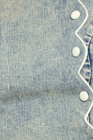 Close-up of blue denim fabric with button and scallop details | Flying Tomato