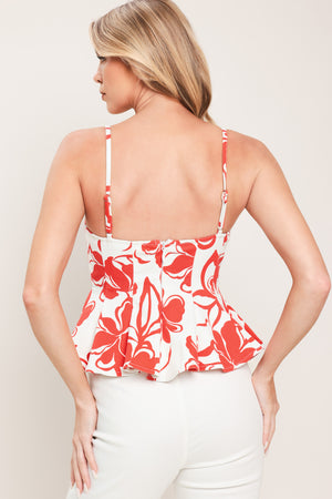 Woman wearing a red and white floral top with straps, peplum and back zipper closure | Flying Tomato