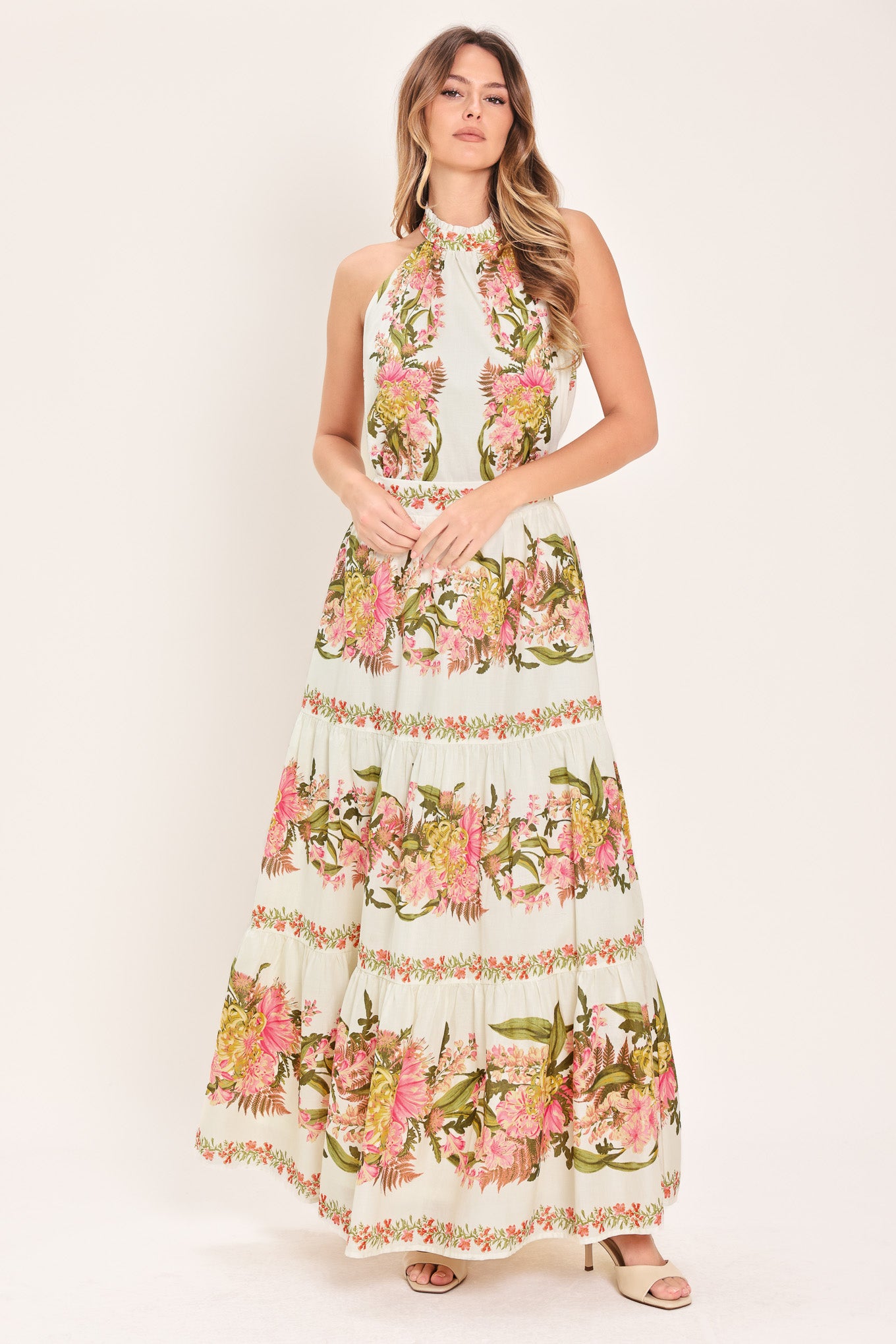 Woman wearing a floral sleeveless woven halter top with back neck button closure | Flying Tomato