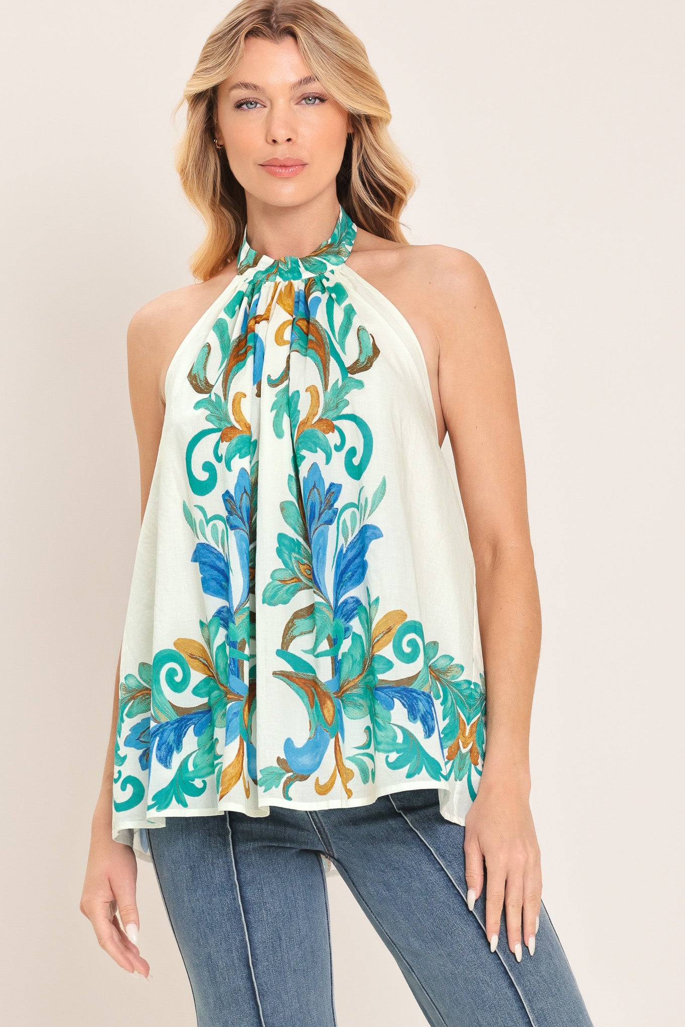 Woman wearing an ivory with mint and blue floral halter top | Flying Tomato