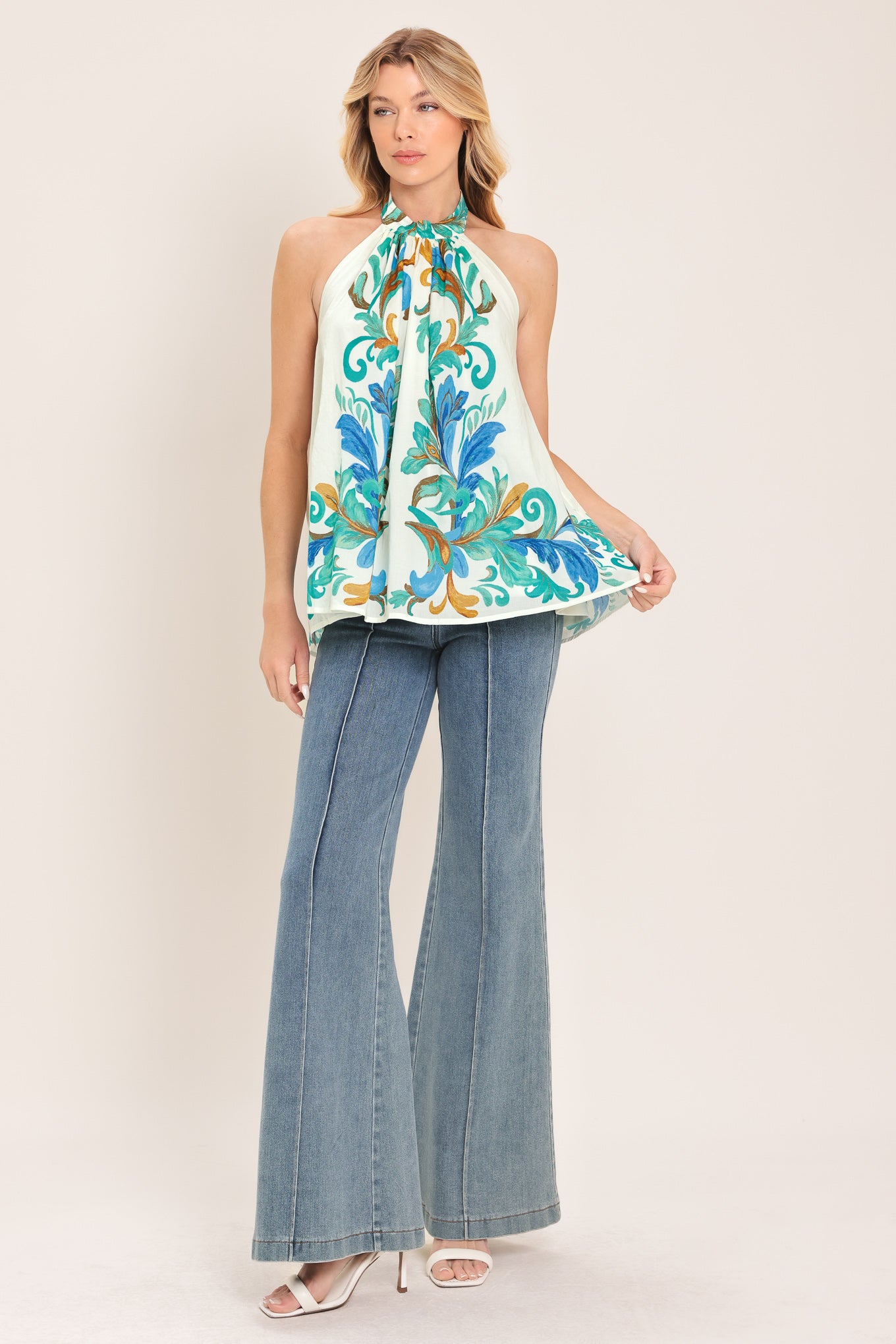 Woman wearing an ivory with mint and blue floral halter top | Flying Tomato