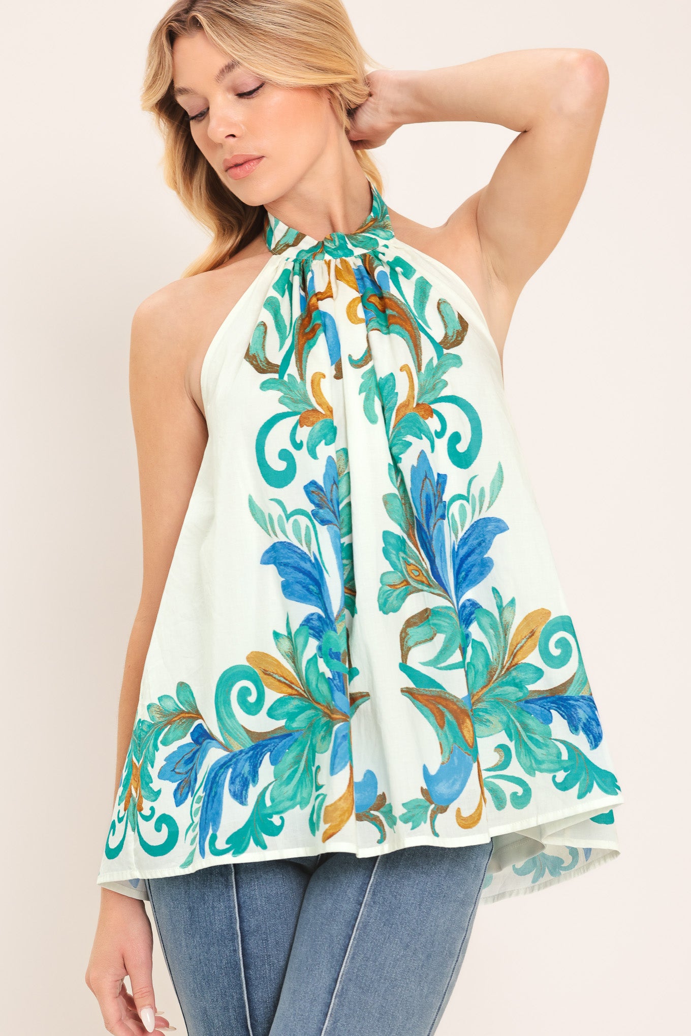 Woman wearing an ivory with mint and blue floral halter top | Flying Tomato