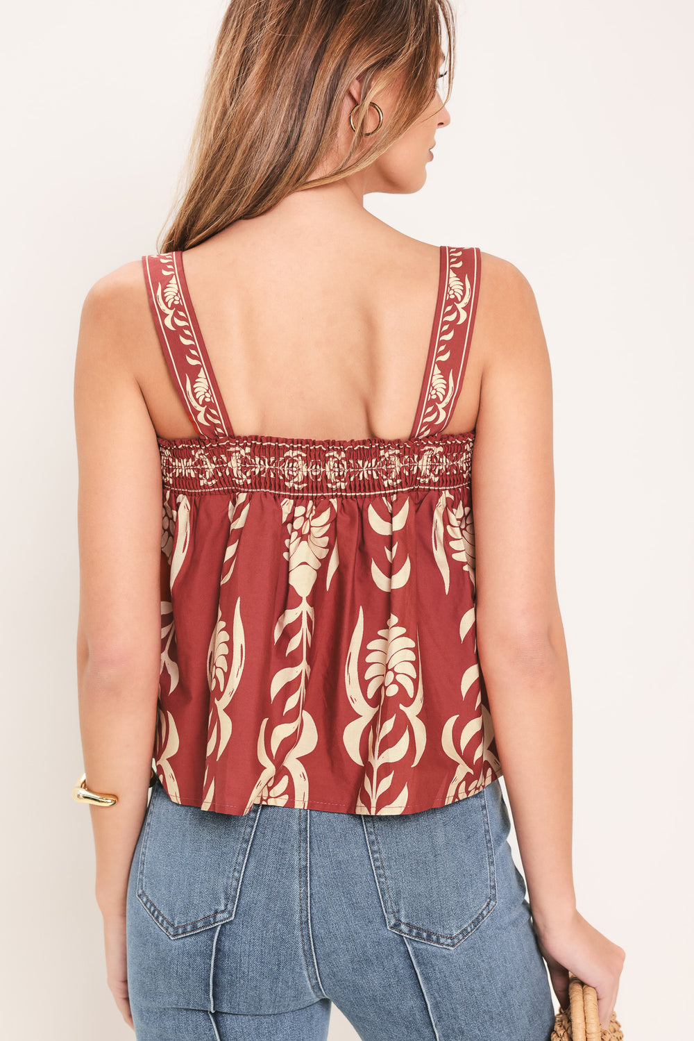 Woman wearing a red and beige patterned top with straight neckline and straps | Flying Tomato