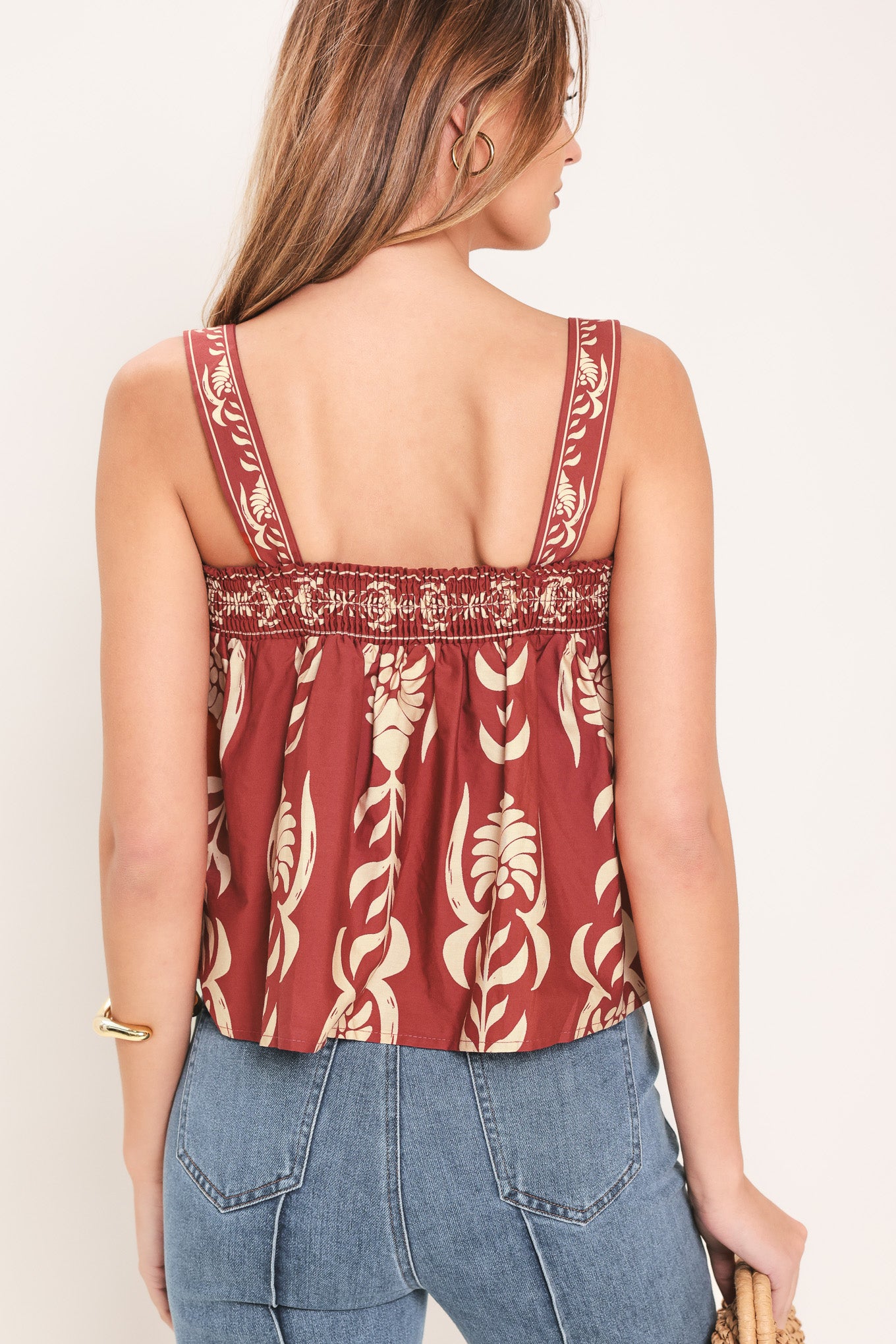 Woman wearing a red and beige patterned top with straight neckline and straps | Flying Tomato