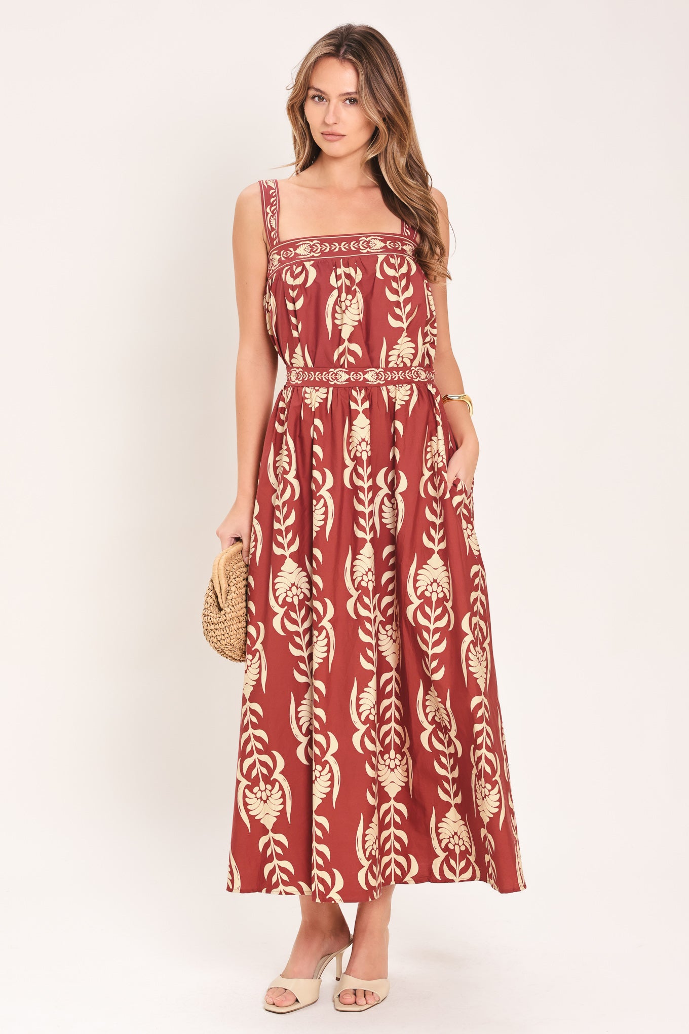 Woman wearing a red and beige patterned top with straight neckline and straps | Flying Tomato