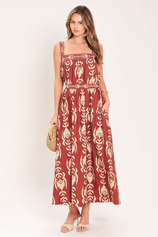Woman wearing a red and beige patterned top with straight neckline and straps | Flying Tomato
