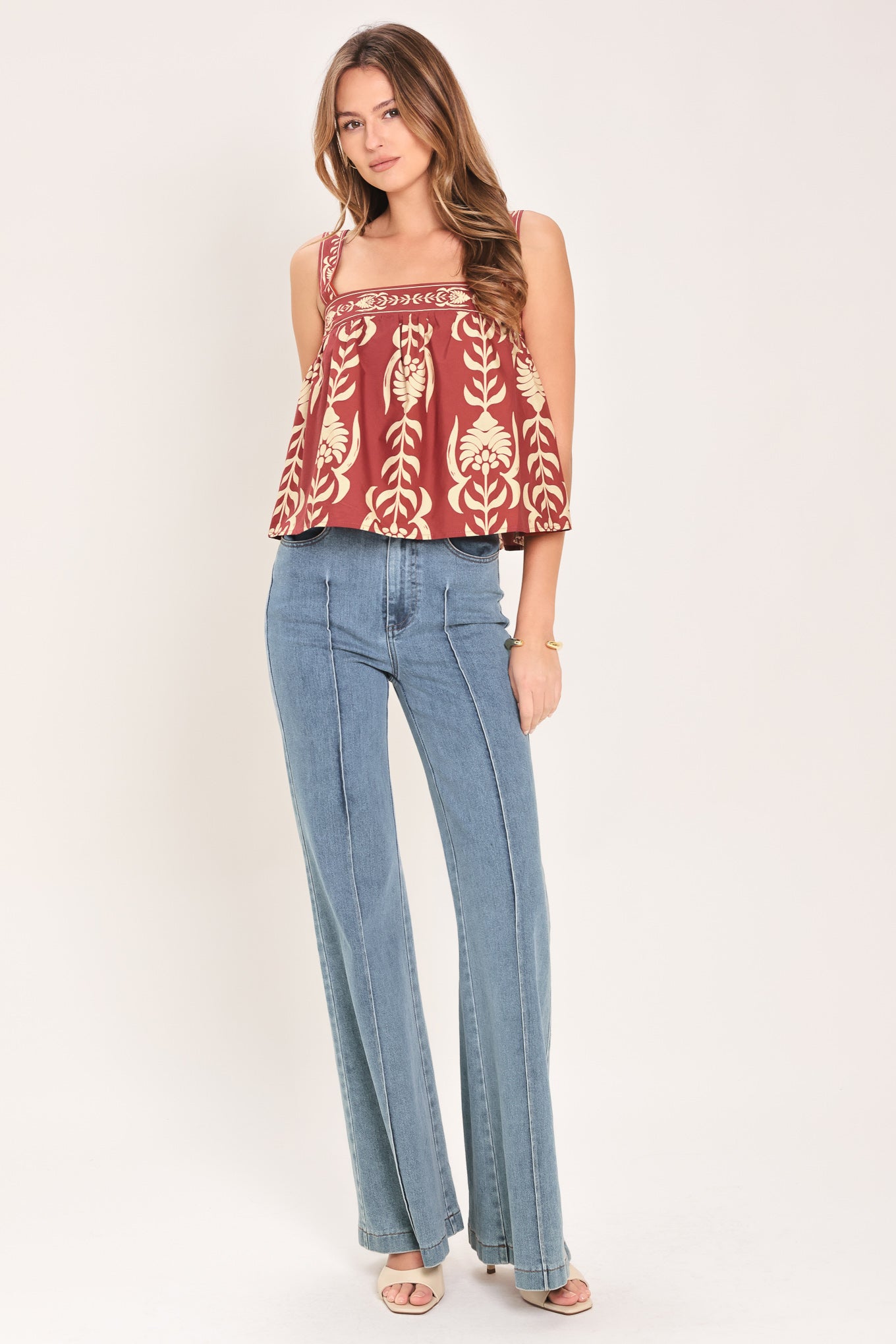 Woman wearing a red and beige patterned top with straight neckline and straps | Flying Tomato