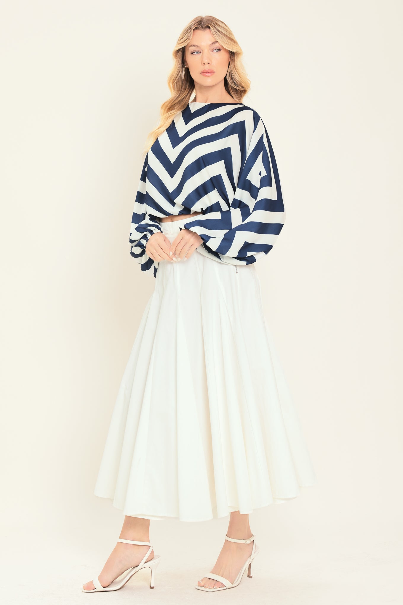 Woman wearing a navy and white chevron patterned top featuring wide neckline, dolman sleeve, elastic waist and back neck button closure | Flying Tomato