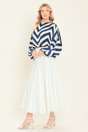 Woman wearing a navy and white chevron patterned top featuring wide neckline, dolman sleeve, elastic waist and back neck button closure | Flying Tomato