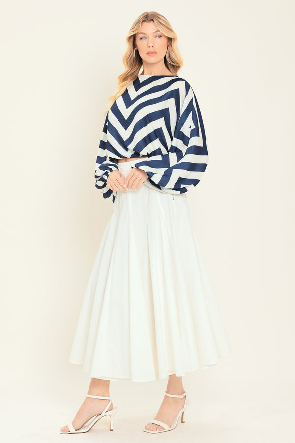 Woman wearing a navy and white chevron patterned top featuring wide neckline, dolman sleeve, elastic waist and back neck button closure | Flying Tomato