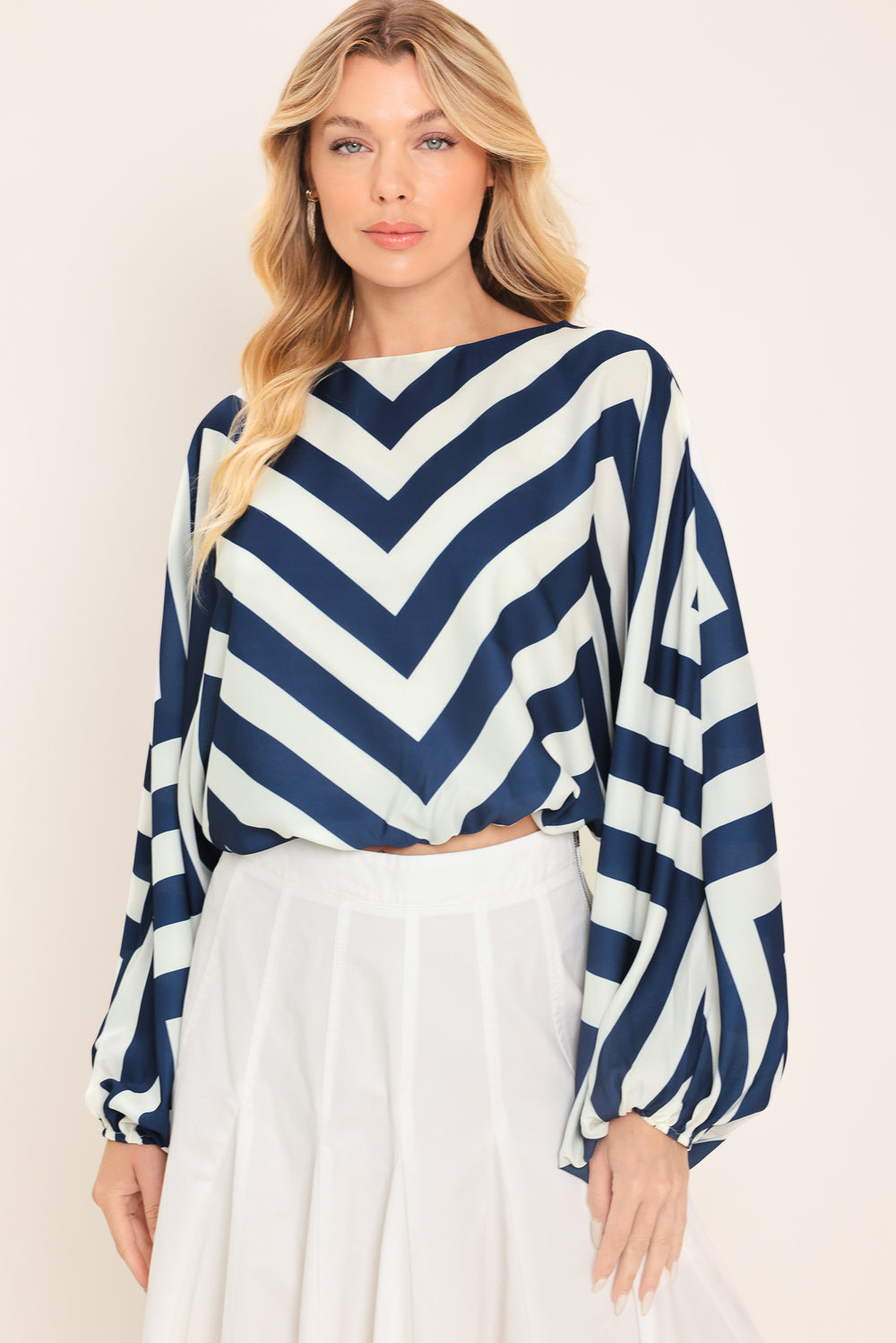Woman wearing a navy and white chevron patterned top featuring wide neckline, dolman sleeve, elastic waist and back neck button closure | Flying Tomato