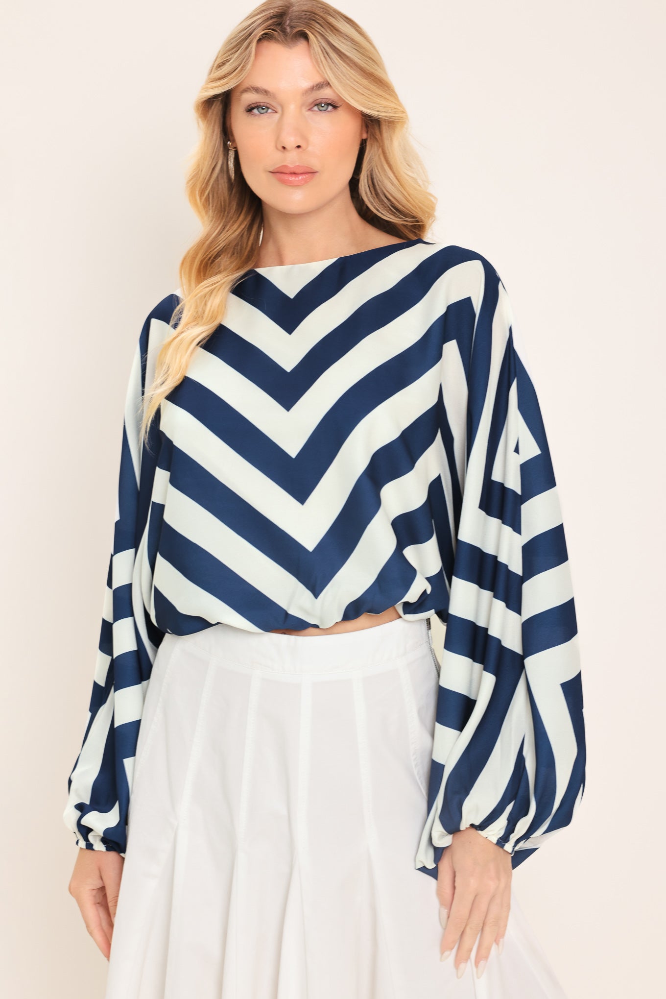 Woman wearing a navy and white chevron patterned top featuring wide neckline, dolman sleeve, elastic waist and back neck button closure | Flying Tomato