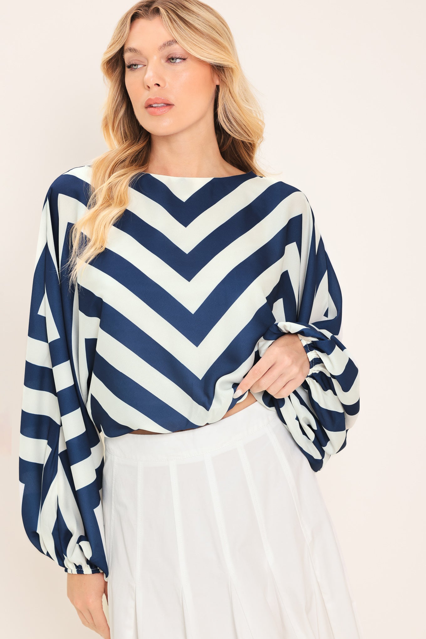 Woman wearing a navy and white chevron patterned top featuring wide neckline, dolman sleeve, elastic waist and back neck button closure | Flying Tomato