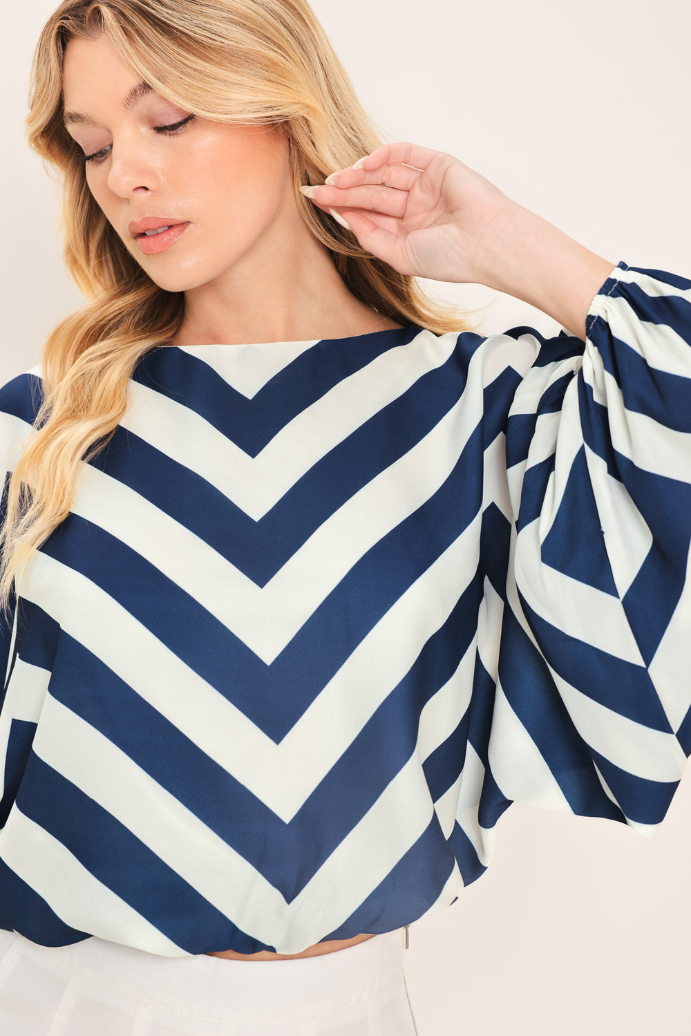 Woman wearing a navy and white chevron patterned top featuring wide neckline, dolman sleeve, elastic waist and back neck button closure | Flying Tomato