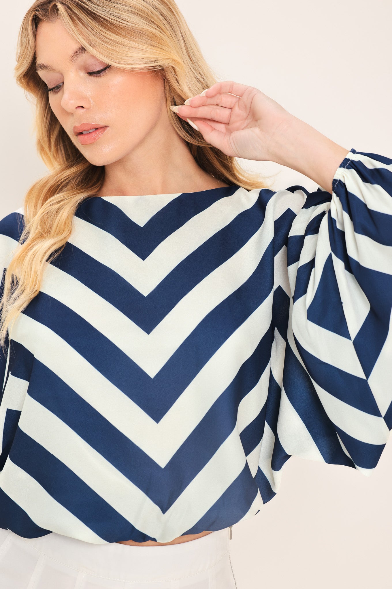 Woman wearing a navy and white chevron patterned top featuring wide neckline, dolman sleeve, elastic waist and back neck button closure | Flying Tomato