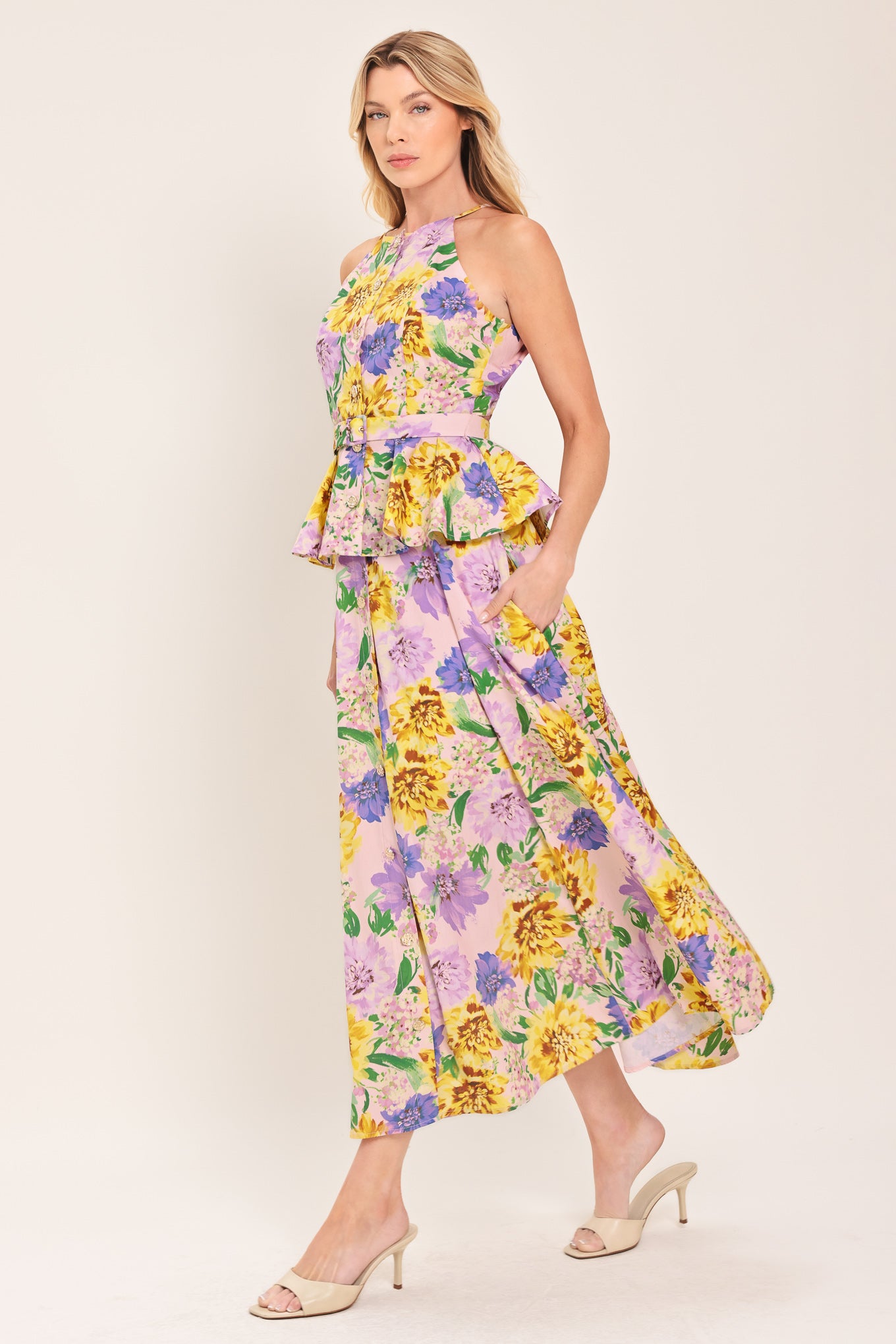 Woman wearing a yellow and purple floral top with front button down, self belt and peplum | Flying Tomato