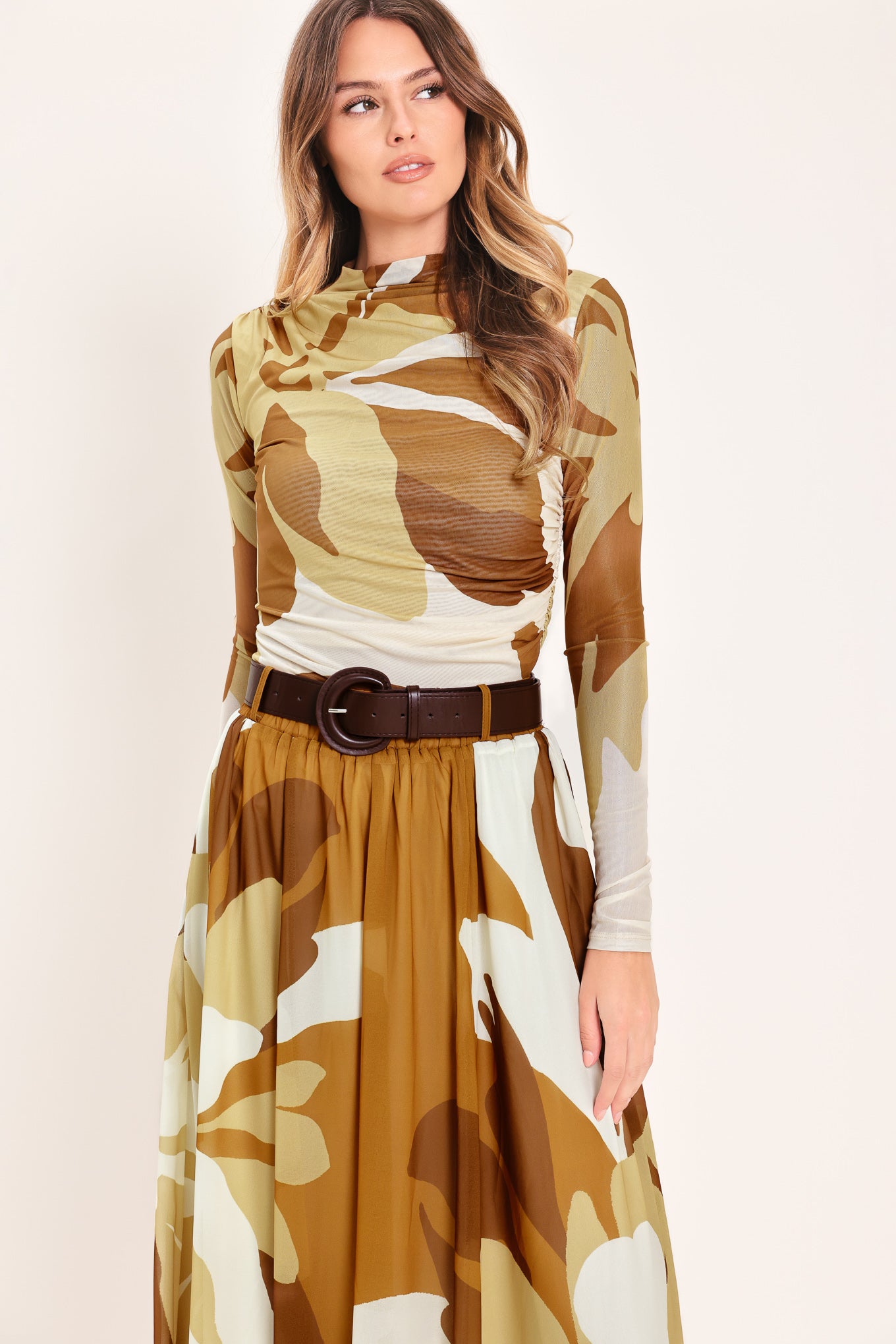 Woman wearing a multicolor brown, yellow, and ivory long-sleeve power mesh top with funnel neck and side shirring | Flying Tomato