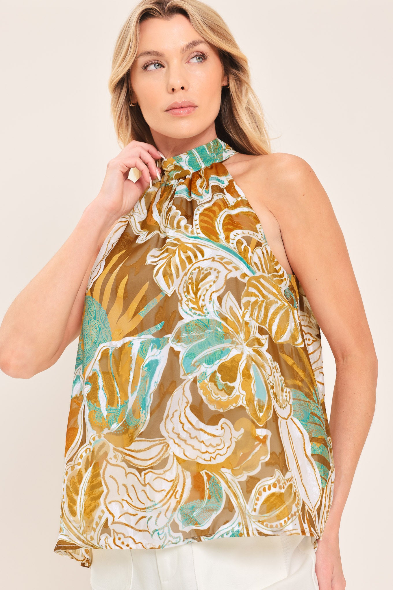 Woman wearing a sleeveless tropical floral jacquard printed top with halter neckline with back neck tie | Flying Tomato