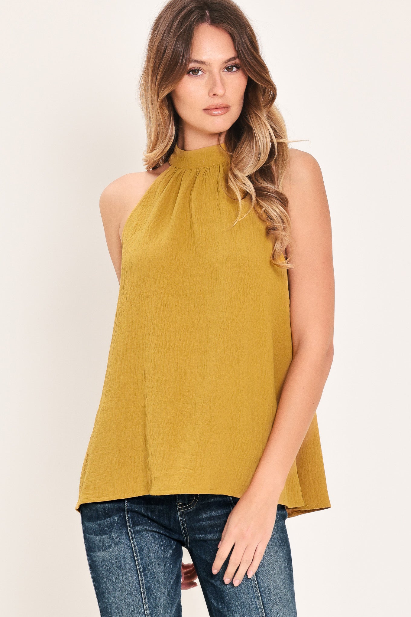 Woman wearing a mustard yellow sleeveless halter top | Flying Tomato