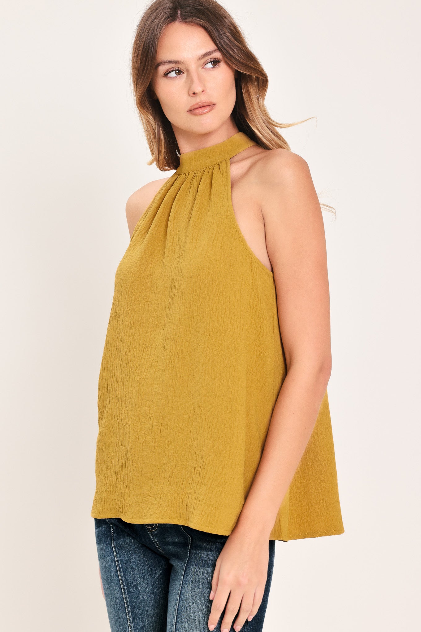 Woman wearing a mustard yellow sleeveless halter top | Flying Tomato