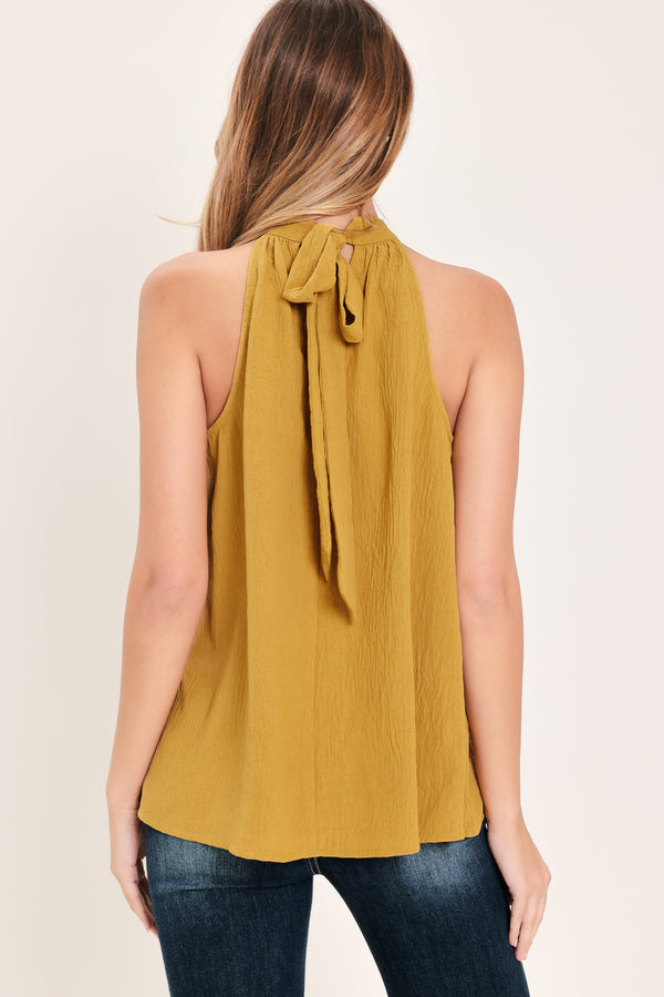 Woman wearing a mustard yellow sleeveless halter top | Flying Tomato