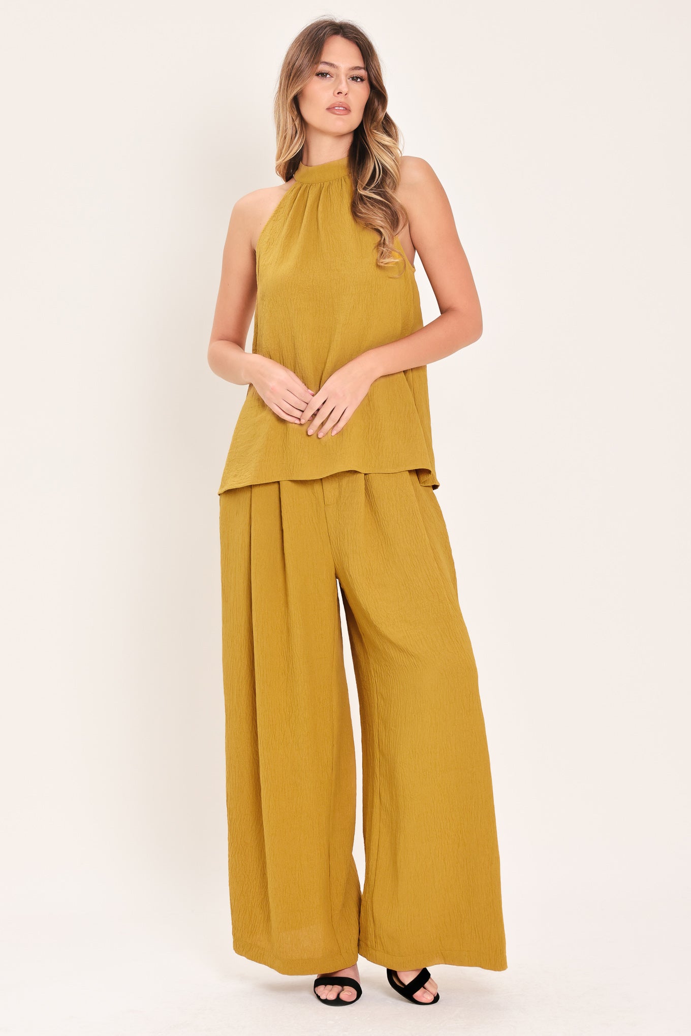 Woman wearing a mustard yellow sleeveless halter top | Flying Tomato