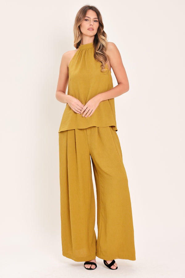 Woman wearing a mustard yellow sleeveless halter top | Flying Tomato