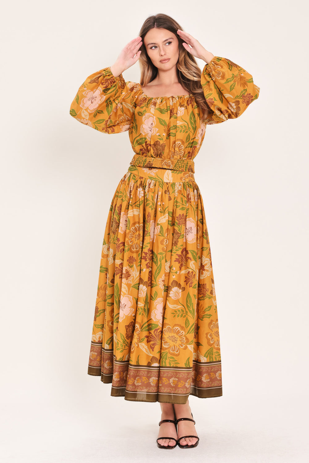 Woman wearing a yellow floral printed blouse featuring square neckline, long sleeve and smocked waistband | Flying Tomato