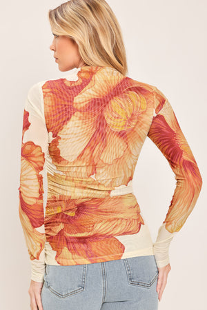 A woman wearing a long-sleeve mock neck power mesh top with a orange and ivory abstract leaf pattern | Flying Tomato