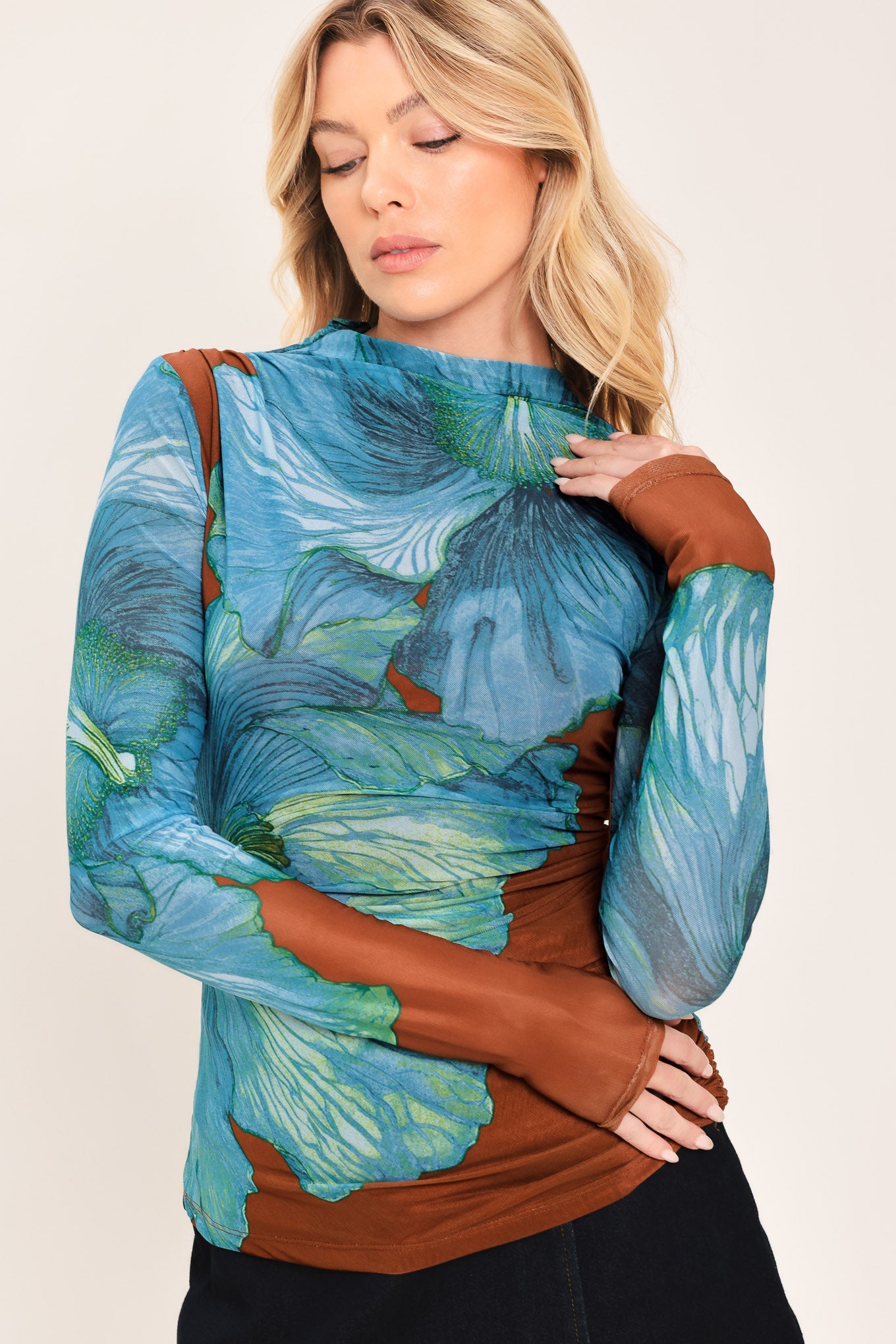 A woman wearing a long-sleeve mock neck power mesh top with a blue and green abstract leaf pattern | Flying Tomato