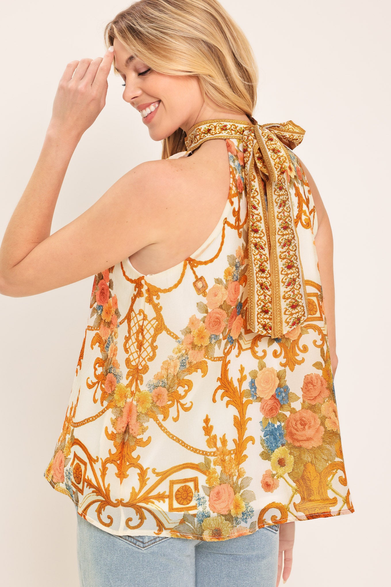 Woman wearing a sleeveless floral and geometric baroque patterned top | Flying Tomato