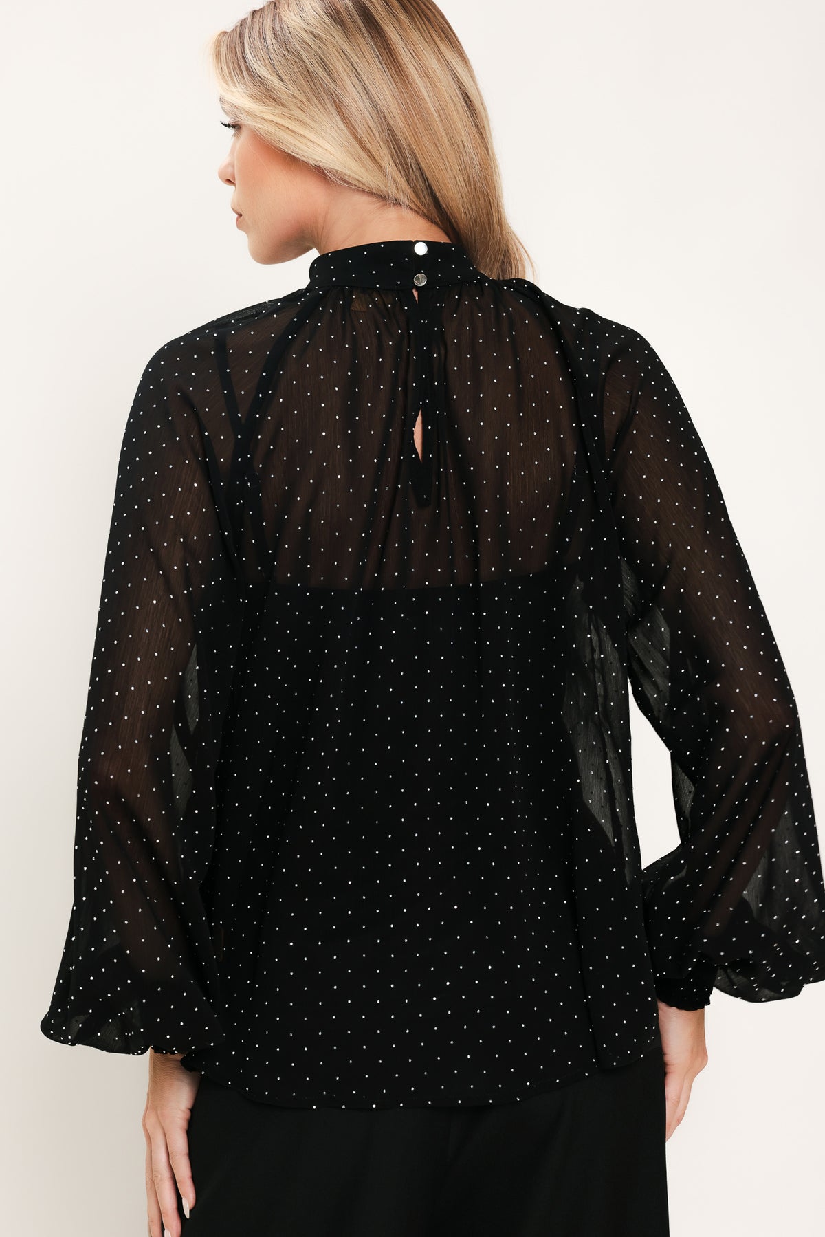 Woman wearing a long sleeve, mock neck, black top with small rhinestones | Flying Tomato