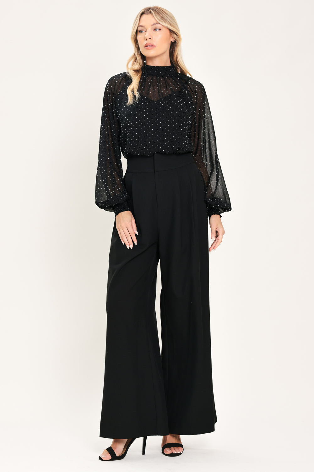 Woman wearing a long sleeve, mock neck, black top with small rhinestones | Flying Tomato