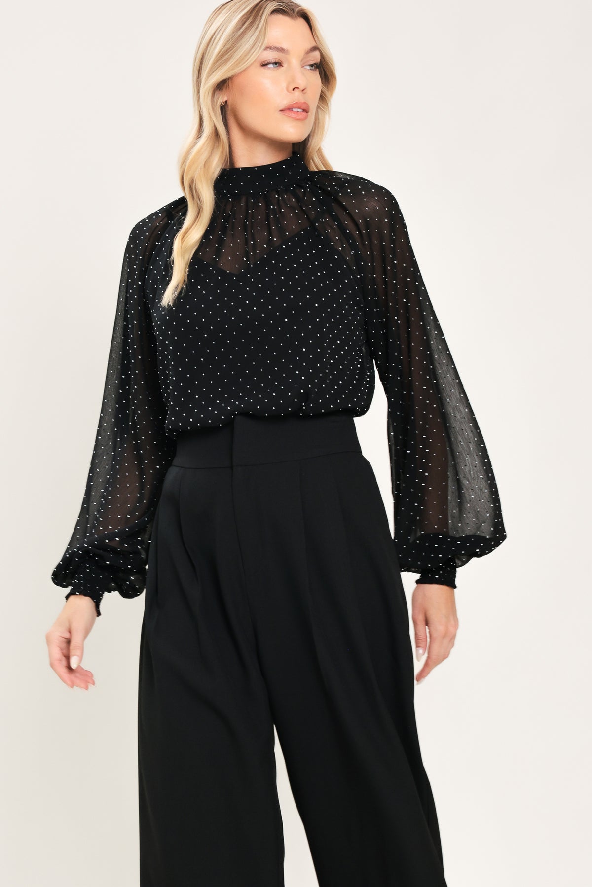 Woman wearing a long sleeve, mock neck, black top with small rhinestones | Flying Tomato