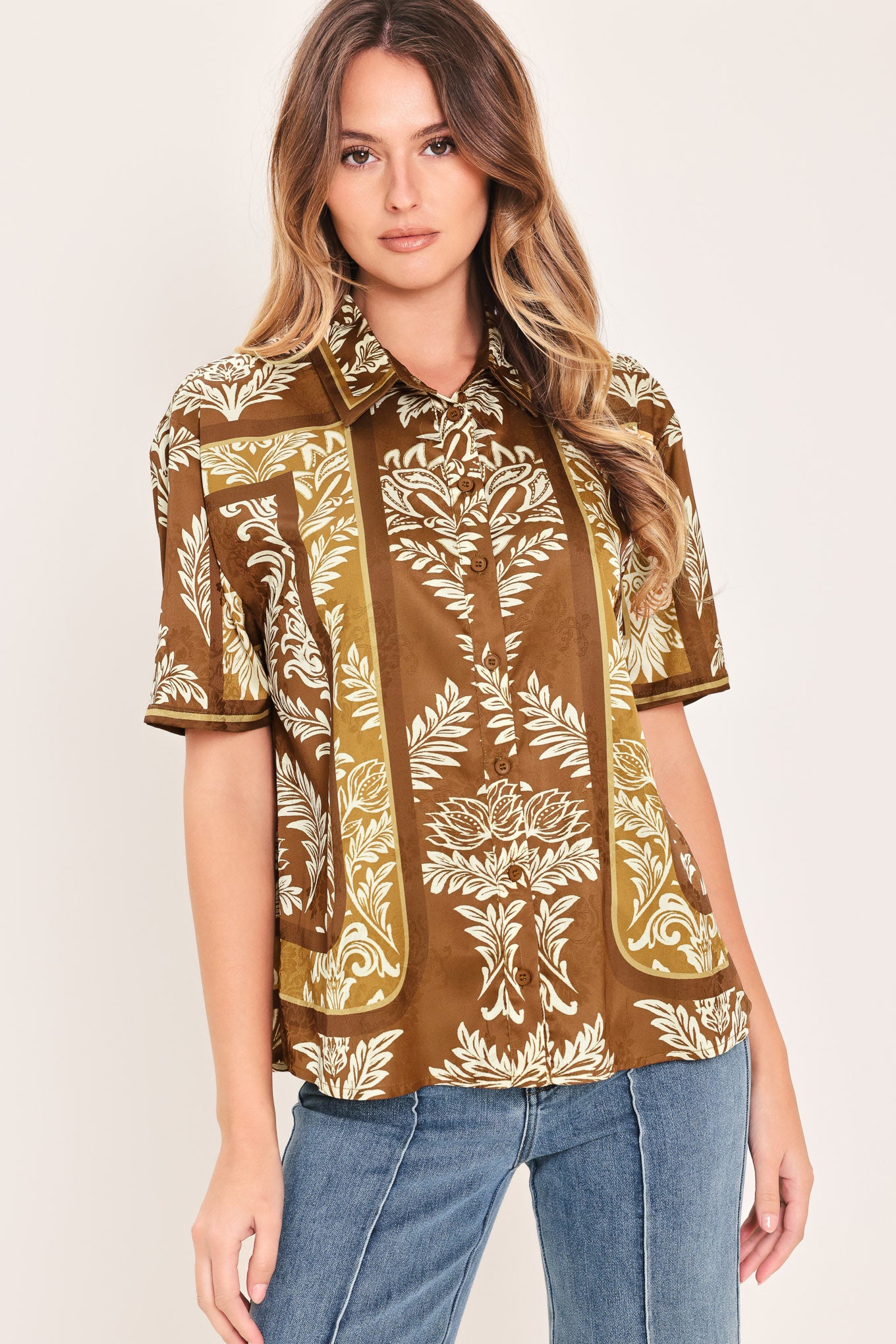 Woman wearing a brown floral patterned button down top | Flying Tomato