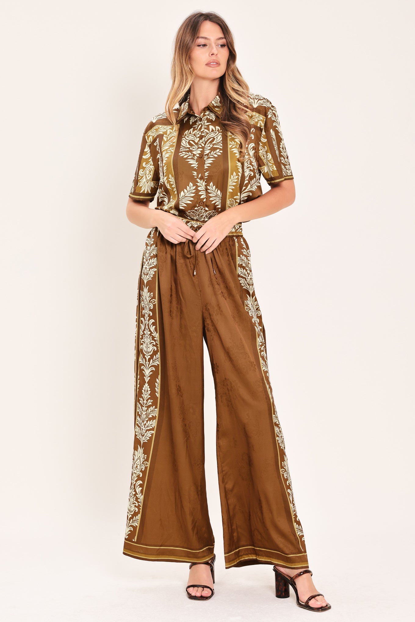 Woman wearing a brown floral patterned button down top | Flying Tomato